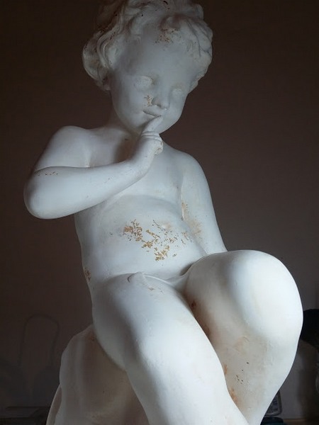 Cette image représente une statuette en platre brut et patinée